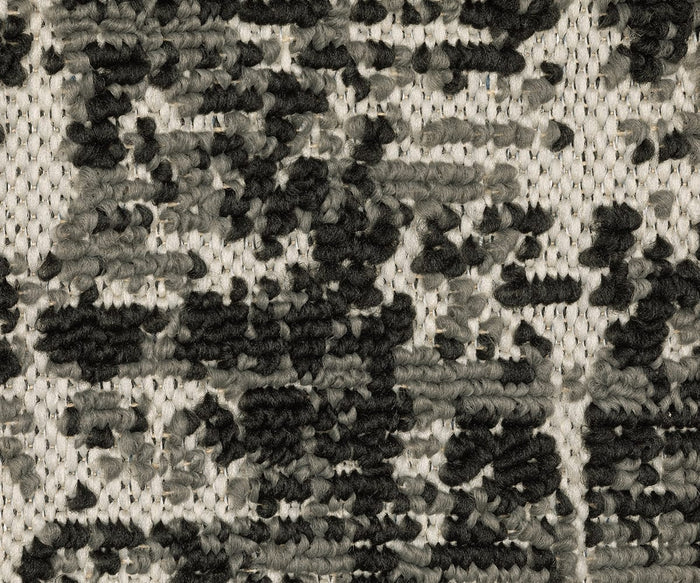 Close-up of the Oriental Weavers Torrey / 531W Rug showcasing thick black and gray yarn woven into abstract, pixelated motifs against a beige background. The neutral palette highlights the soft, slightly raised texture, reminiscent of a flatwoven rug.