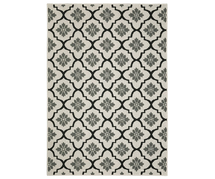 The Oriental Weavers Torrey / 5562E Rug features a rectangular flatwoven design with a repeating geometric floral pattern in Grey/Multi tones on a cream background. Its symmetrical shapes and stylized flowers are arranged in a grid-like layout, adding dynamic texture and visual interest.