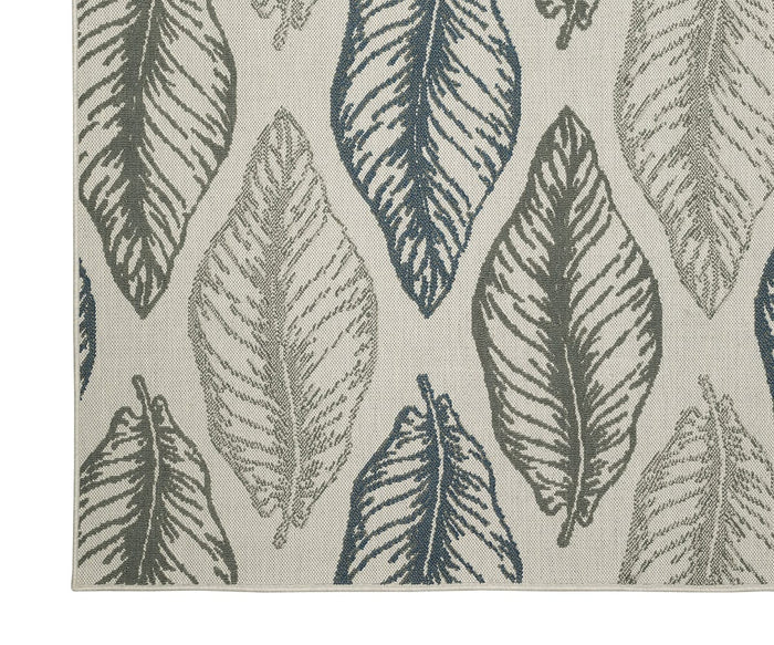 A close-up of the Oriental Weavers Torrey / 5570Y Rug highlights a repeating pattern of large, textured leaves in shades of gray and blue on a beige background, accented by abstract motifs and layered texture for added depth.