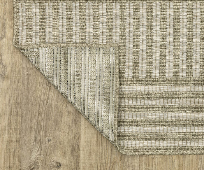 The Oriental Weavers Tortuga / TR02A Rug, featuring beige and cream stripes and one corner flipped to show the underside, is a woven polypropylene piece from the Tortuga Collection. Placed on a light wood floor, this easy-care rug lends a touch of modern elegance to any space.