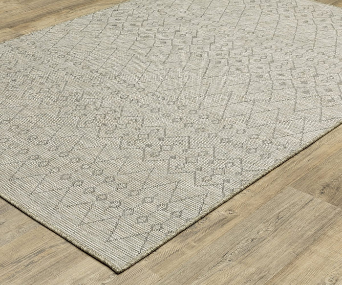 The Oriental Weavers Tortuga / TR04A Rug, in beige with a textured, woven finish, lies on the light wood floor. Its easy-care surface features subtle geometric patterns of diamonds and hexagons in light gray.