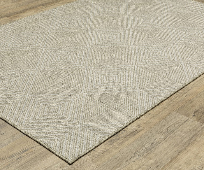 The Oriental Weavers Tortuga / TR05A Rug, featuring a subtle geometric pattern of concentric diamond shapes, sits atop a light brown wooden floor. Part of the Tortuga Collection, this easy-care beige area rug offers a textured and modern look. The image is captured from an angled top perspective.