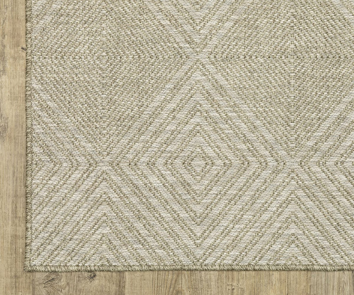 The Oriental Weavers Tortuga / TR05A Rug, featuring a beige hue and diamond geometric pattern from the Tortuga Collection, rests on a wooden floor. Crafted from easy-care polypropylene, this rug offers a textured surface and understated design for a neutral, modern aesthetic.
