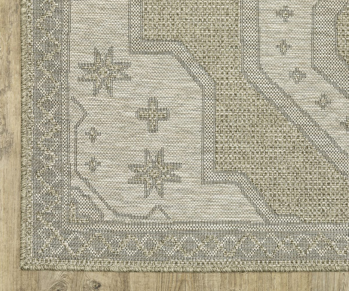The Oriental Weavers Tortuga / TR08A Rug features beige and gray tones with geometric patterns and star-like designs, displayed here on a wooden floor to highlight its corner detail and border. Made from easy-care polypropylene, this rug combines stylish appeal with everyday durability.