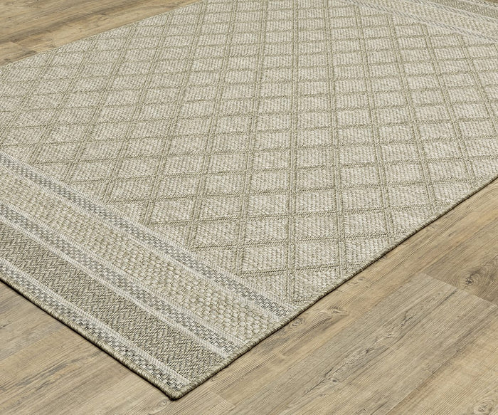 The Oriental Weavers Tortuga / TR10A Rug, crafted from beige polypropylene and showcasing a diamond pattern with decorative striped borders, is placed on a light wood floor.