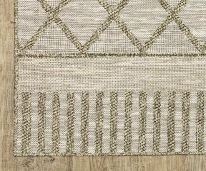 The Oriental Weavers Tortuga / TR11A Rug is a beige woven piece featuring geometric patterns: crisscrossing diamond shapes on top, horizontal stripes in the middle, and vertical stripes at the bottom. Made from easy-care polypropylene, this rug is shown placed on a light wood floor.