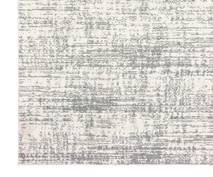 The Oriental Weavers Verona / 1803H Rug showcases a subtle abstract pattern in light gray tones on a white background, offering a textured, modern aesthetic. Crafted from soft polyester microfiber, this rug features a non-uniform design in a neutral palette for a contemporary feel. Only part of the rug is shown.