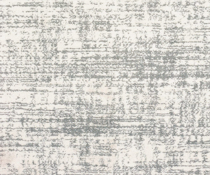 A close-up of the Oriental Weavers Verona / 1803H Rug reveals its textured polyester microfiber surface against a white background, showcasing a distressed, abstract gray pattern reminiscent of brush strokes or faint lines. This rug adds subtle sophistication to any space with its neutral palette design.