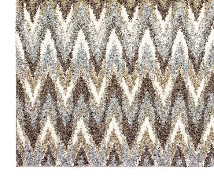 The Oriental Weavers Verona / 4D Rug features a plush, shaggy texture and showcases a zigzag chevron pattern in brown, beige, white, and light blue tones. Made from soft polyester microfiber, this rug offers contemporary style and comfort with its neutral color palette—perfect for enhancing any space.