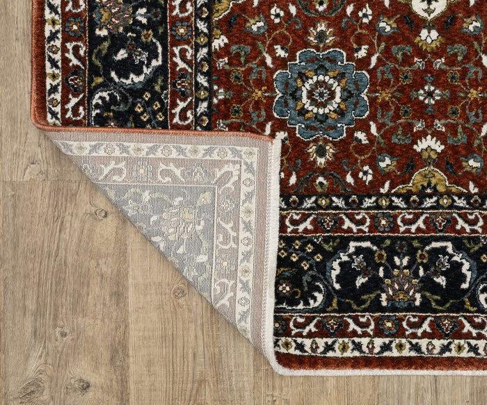 A corner of the Oriental Weavers Vivian / VI04B Rug is folded over, revealing the underside. This Persian-inspired rug showcases floral designs in blue, red, black, and white—a traditional color palette—on a hardwood floor.