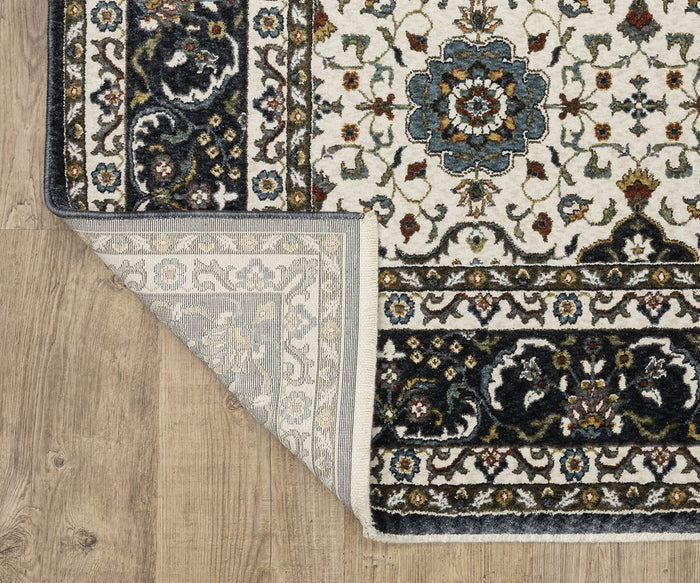A corner of the Oriental Weavers Vivian / VI04D Rug with floral patterns is folded over, exposing its underside. Inspired by Persian designs, this rug displays a traditional palette of blue, ivory, and beige as it rests on a wooden floor.