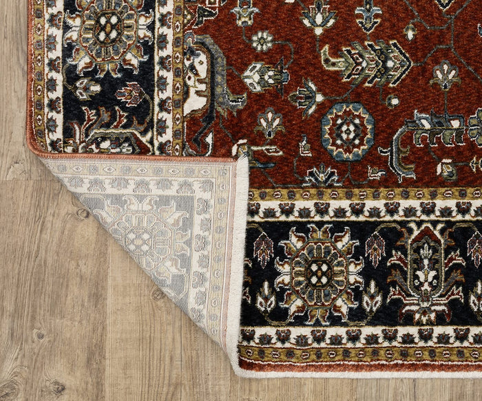 The Oriental Weavers Vivian / VI05X Rug, featuring traditional Persian-inspired floral and geometric patterns in a classic red, black, and cream color palette, rests on wooden flooring with one corner folded over to display its lighter underside.