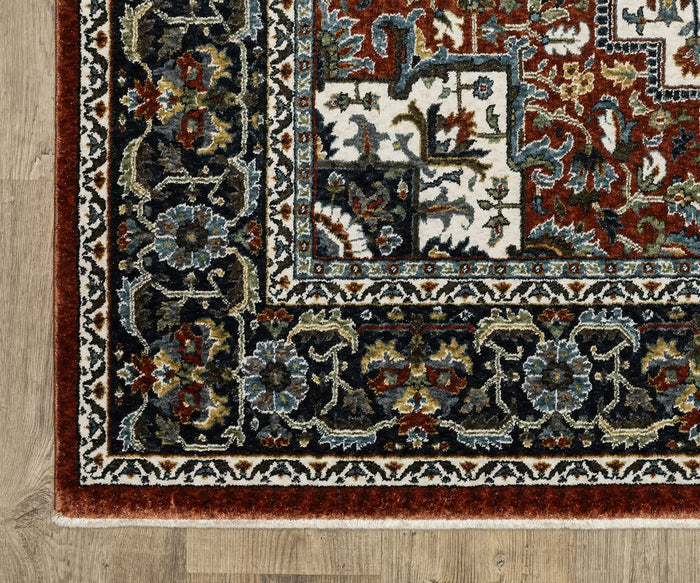 Corner of the Oriental Weavers Vivian / VI06A Rug, showcasing intricate floral patterns in shades of red, navy, green, and cream on a light wood floor. Inspired by traditional palette rugs, this rug features a detailed border and a visible fringe edge at the bottom.