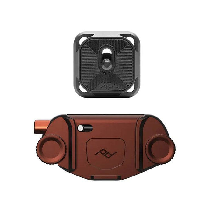 Peak Design Capture camera clip securely holding a camera on a backpack strap with quick-release button and metal clip.