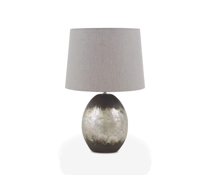 Introducing the Pernilla Lamp—a modern piece featuring a round, silver leaf base accented with black and topped with a large, light gray fabric lampshade. Set against a plain white background, this elegant design serves as a striking accent for any contemporary interior.