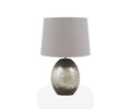 Introducing the Pernilla Lamp—a modern piece featuring a round, silver leaf base accented with black and topped with a large, light gray fabric lampshade. Set against a plain white background, this elegant design serves as a striking accent for any contemporary interior.