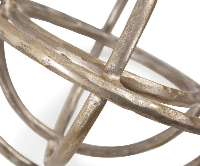 Close-up of the Planetary Rings Sculpture, showcasing intersecting metallic rings that form a geometric, spherical design against a white background. Crafted from aluminum, the metal surface features a textured finish with a slightly tarnished appearance, evoking its timeless allure.
