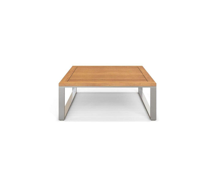 The Playa Mar Outdoor Coffee Table, featuring a teak finish wooden top and stainless steel legs, is shown from the front against a white background.