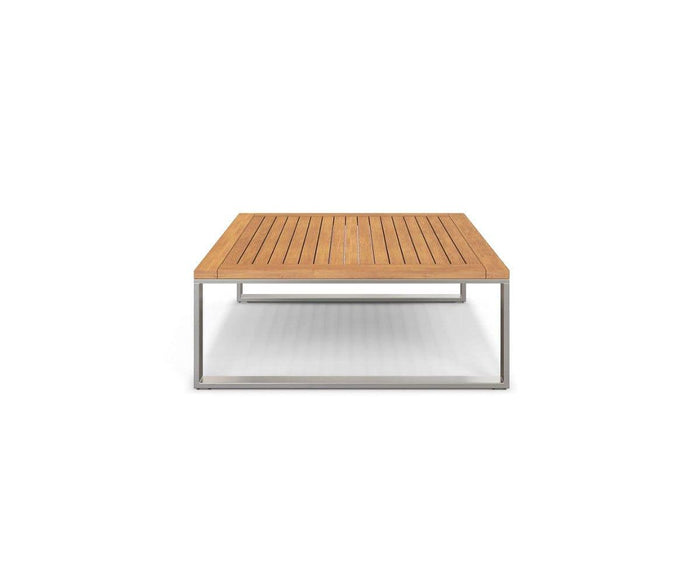 The Playa Mar Outdoor Coffee Table, part of the Playa Mar Collection, features a rectangular wooden design with a teak finish and a slatted top. Supported by a minimalist metal frame, this versatile outdoor coffee table blends style and durability, shown here against a plain white background.