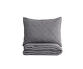 The Plush Diamonds Quilt + Sham Set in grey is displayed with the quilt folded and the matching quilted sham propped behind it, both showcasing a subtle plush diamond pattern against a plain white background.