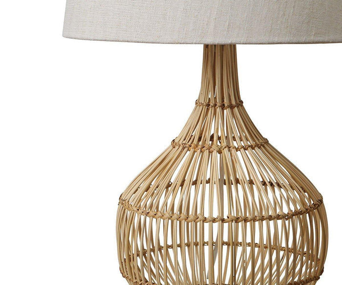 The Reilu Table Lamp, with its woven rattan base and white fabric lampshade, is shown against a plain white background—perfect for bringing a touch of boho chic decor to any space.