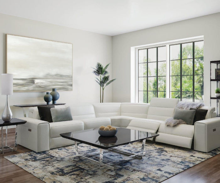 Modern living room with a white sectional sofa, glass coffee table with stainless steel legs, abstract rug, large window, potted plant, the Sieva End Table, and a neutral-toned abstract painting on the wall. Bright, natural light fills the space.