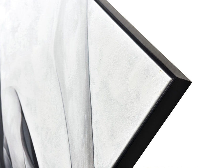 Close-up of the Silk Air II Oil Painting, a framed canvas artwork featuring white textured paint with subtle light gray shading, photographed at an angle against a white background—an embodiment of contemporary elegance through its refined details and dynamic artistry.