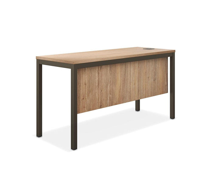 The Slater 47″ Desk is a contemporary office desk featuring a rectangular wood grain surface, sleek black metal legs, a modesty panel, and a circular cable management hole on the desktop, all presented against a white background.