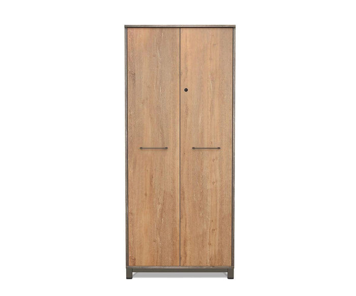A tall Slater High Cabinet With Doors from the collection, crafted in oak and slate grey driftwood, features two vertical doors with horizontal metal handles. The cabinet displays a light brown wood grain finish and stands on short legs.