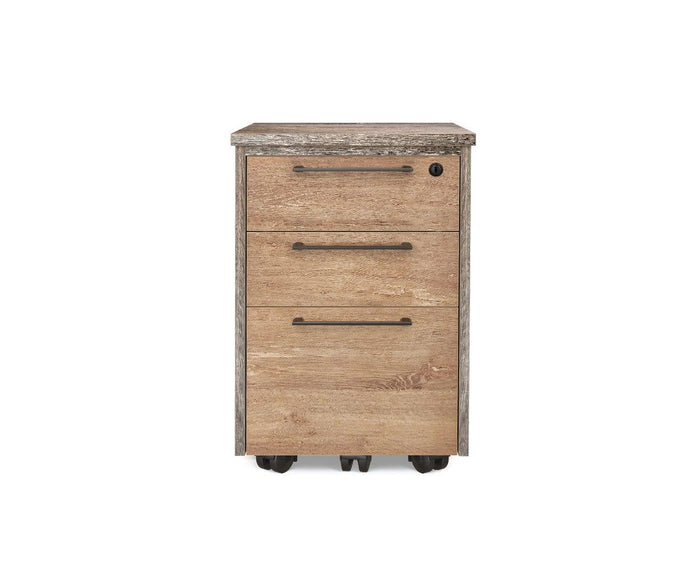 Introducing the Slater Mobile Pedestal in Oak/Slate Grey Driftwood, a wooden filing cabinet designed with three lockable drawers featuring sleek metal handles and smooth black caster wheels, all showcased against a white background.