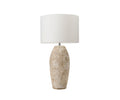 The Stone Shores Table Lamp - Tall features a textured, stone white base and a simple white cylindrical lampshade, set against a white background—perfect for bringing rustic charm to modern home decor.