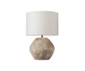 The Stone Shores Table Lamp features a textured, stone-like round base in stone white and a simple white cylindrical lampshade, making it perfect for adding warmth to modern home décor. Shown against a white background.