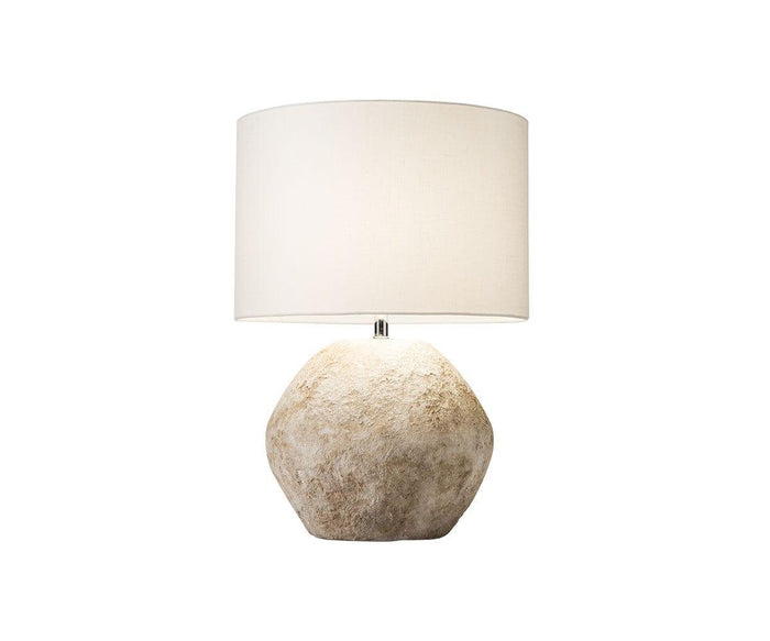 The Stone Shores Table Lamp features a textured, stone-like beige base and a simple white cylindrical lampshade, pictured against a plain white background—perfect for enhancing modern home decor.
