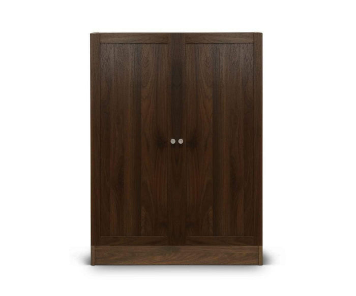 The Stuen Narrow Panel Door is a closed, dark wooden wardrobe featuring two vertical panel doors with round silver handles, standing on a white background—a timeless storage upgrade for any room.