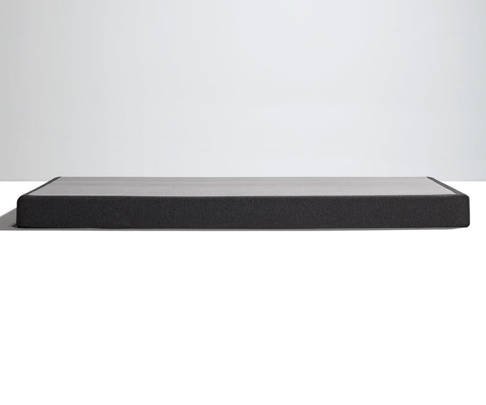 A low, rectangular TEMPUR-FLAT™ Low Profile Foundation with a dark finish is set against a plain white background, providing sturdy support for your TEMPUR-Pedic mattress.