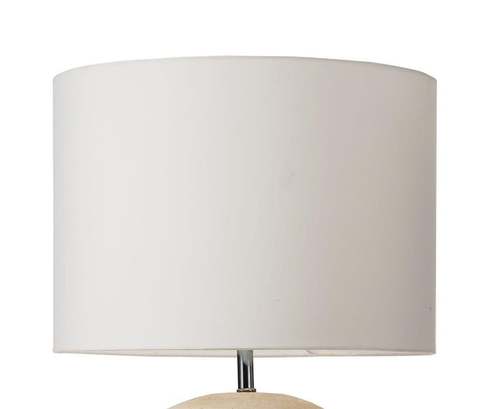 The Textured Clay Lamp, featuring a white fabric lampshade atop its beige base, is displayed against a plain white background.