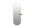The Toive Wall Mirror features a tall oval design with a thin brass metal frame and includes a small circular shelf in matching brass, attached on the right side near the middle. This elegant mirror seamlessly combines style and function, making it perfect for modern interiors.