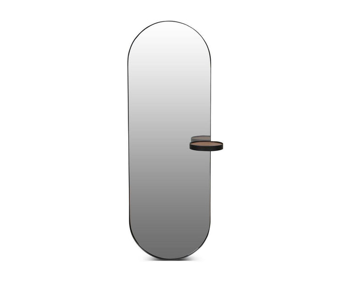 The Toive Wall Mirror features a tall, oval-shaped design with a slender black frame and a small, circular shelf attached to the right side.