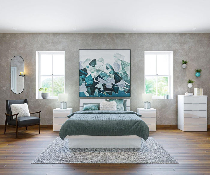 Modern bedroom with a teal and white theme, abstract art above the bed, two windows, a black chair, white dressers, potted plants, and a gray rug on wooden floors. The Toive Wall Mirror adds elegance to one corner of the room, enhancing the airy feel of the space.