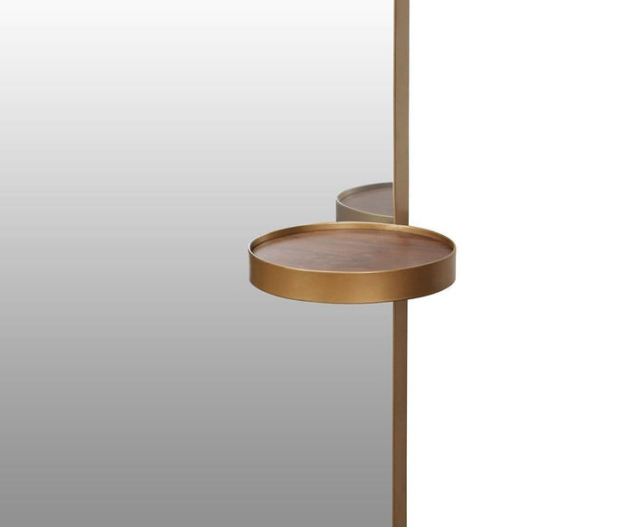 A Toive Wall Mirror with a gradient background fading from white to gray reflects a round, gold metallic tray—resembling a circular shelf—attached to a vertical pole.