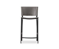 The Torren Counter Stool features a grey cushioned backrest and seat, supported by sleek black wooden legs and a convenient footrest. Its modern design showcases clean lines and a subtly curved seat, making this upholstered counter stool a stylish choice for any contemporary setting.