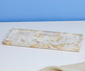 The Tula Rectangle Marble Tray, a handcrafted serveware piece in a white/multi colorway, features an elegant marbled pattern and sits gracefully on a white surface against a light blue background.