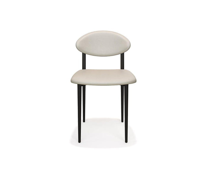 The Turi Dining Chair in Turi Cream features a modern design with a rounded backrest, matching cushioned seat, and four slim black metal frame legs, displayed against a white background.