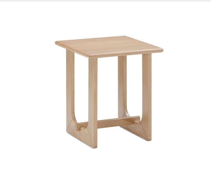 Featuring a simple, modern design with open sides and vertical and horizontal support beams, the Unni Side Table from the Unni Collection is a small, square piece crafted from solid oak that embodies mid-century style.