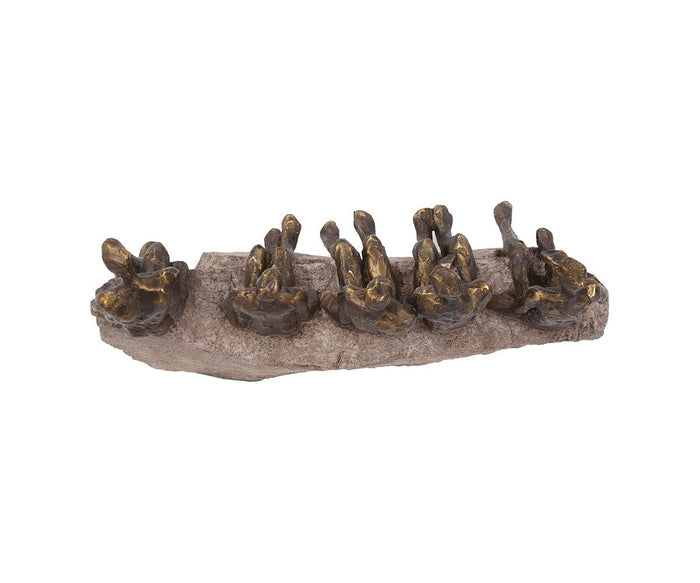 The Waiting Figure Statue showcases several small rabbits with a refined bronze finish, all seated in a row on a textured stone base with their ears upright and facing forward. This bronze sculpture stands out beautifully against the plain white background.