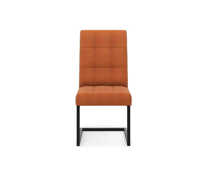 The West Dining Chair features a modern design with a pumpkin-colored velvet cushioned seat and backrest, tufted details, and black metal legs, displayed against a plain white background.